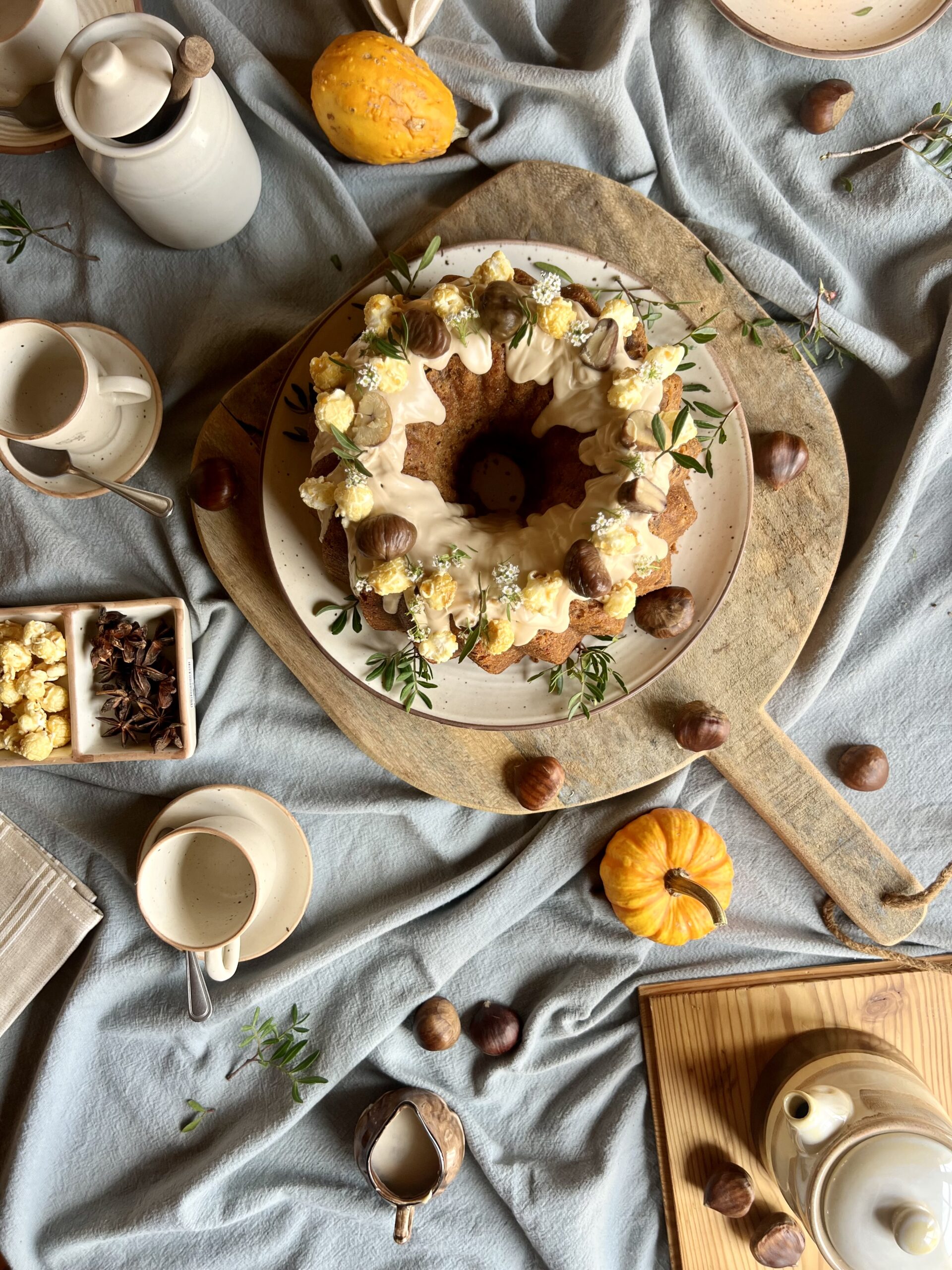 Bizcocho de castañas con cobertura de chocolate blanco, corona de palomitas y flores de temporada