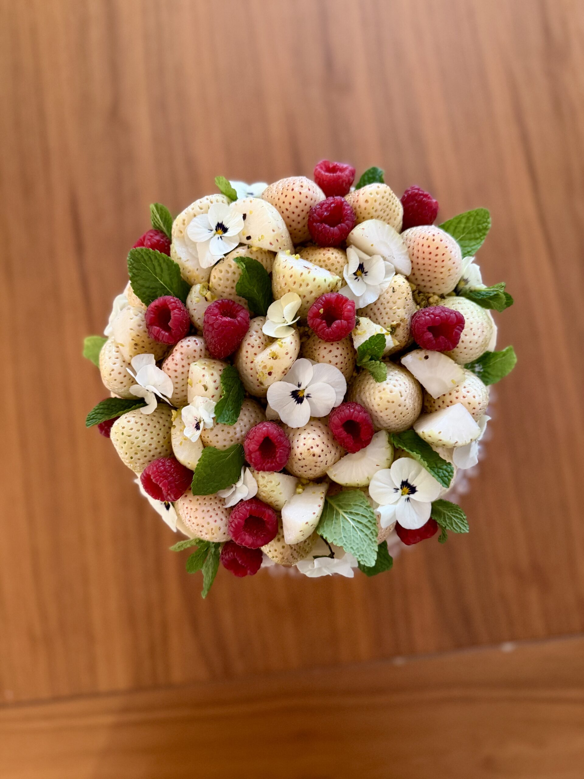 Tarta de chocolate blanco, fresas, piña y pistachos